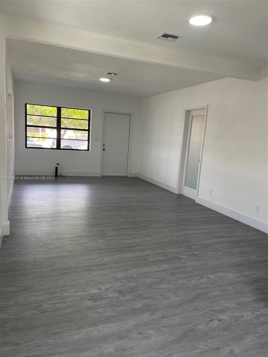50 East 13th Street Hialeah, FL 33010 - Photo 14 of 17 an empty room with wooden floor and windows