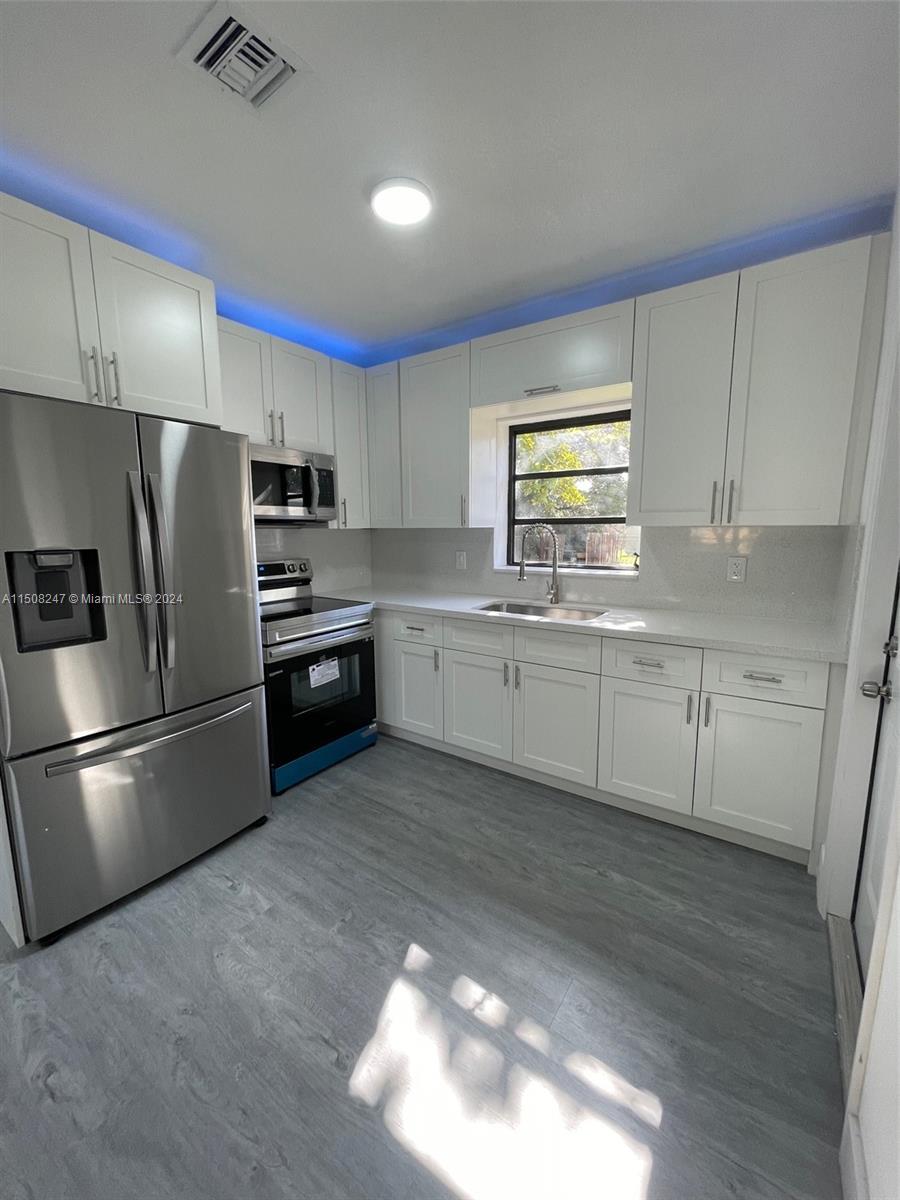 50 East 13th Street Hialeah, FL 33010 - Photo 5 of 17 a kitchen with stainless steel appliances a refrigerator sink and cabinets
