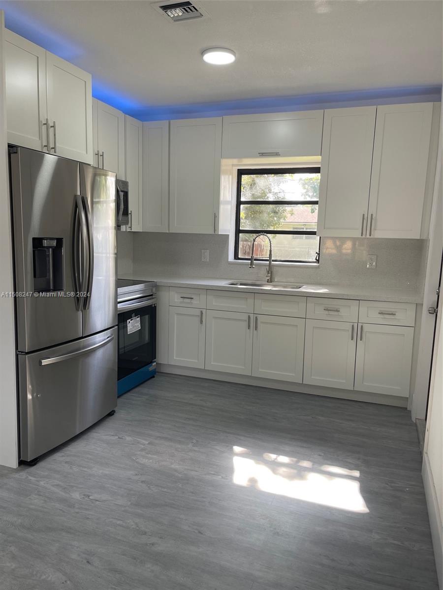 50 East 13th Street Hialeah, FL 33010 - Photo 6 of 17 a kitchen with stainless steel appliances granite countertop a refrigerator a sink a stove a microwave a counter space and cabinets