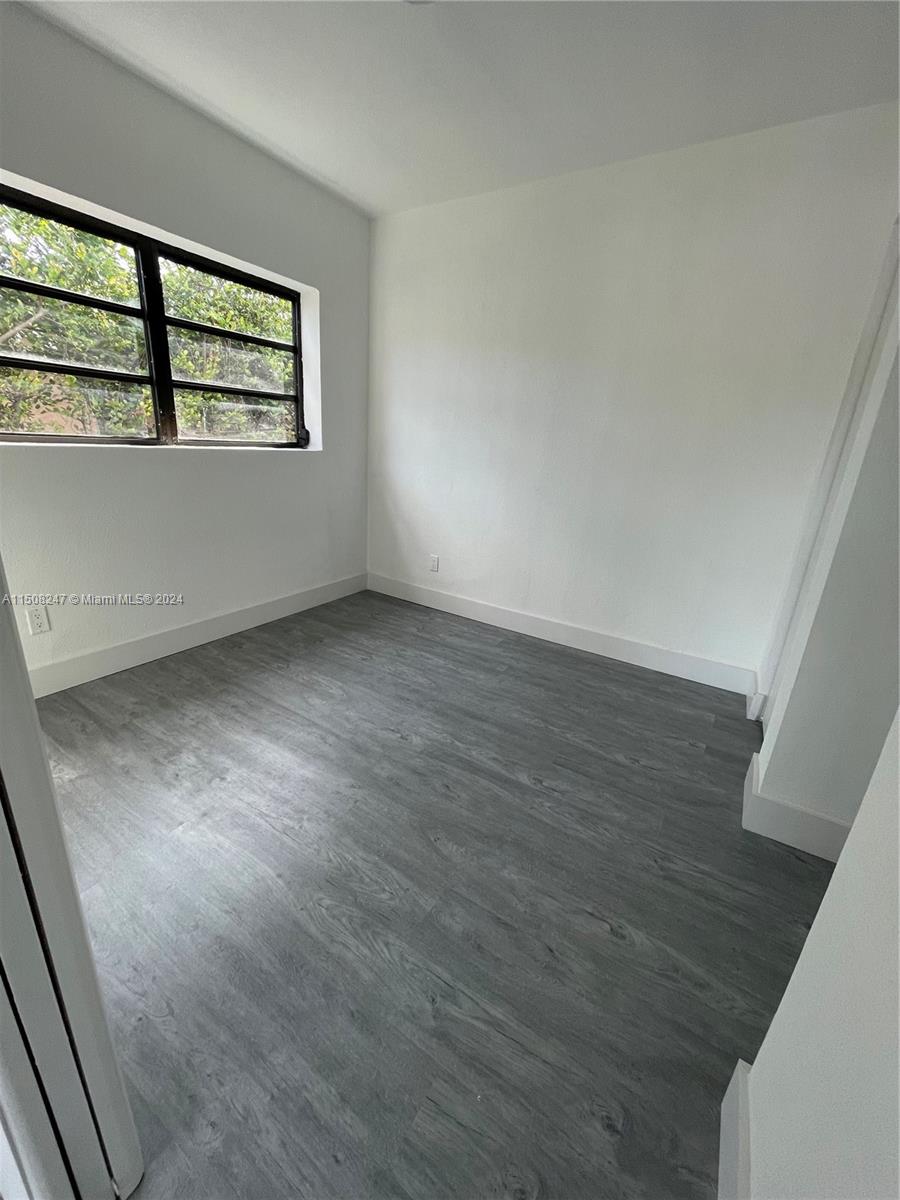 50 East 13th Street Hialeah, FL 33010 - Photo 8 of 17 an empty room with wooden floor and windows