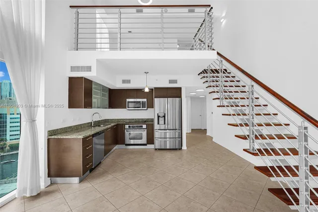 a kitchen with a refrigerator and a stove top oven