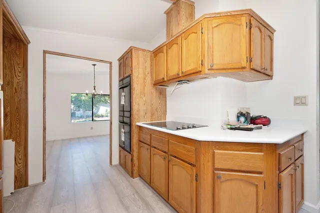 a kitchen with a sink a cabinets and wooden floor