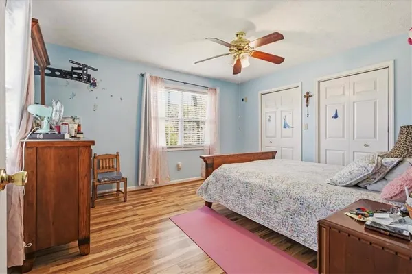a bedroom with a bed and wooden floor