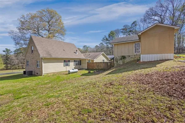 a front view of house with yard and trees in the background