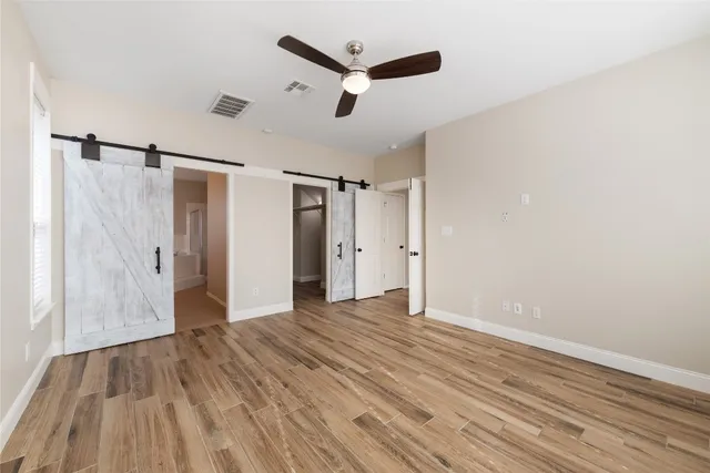 a view of a livingroom with wooden floor and a ceiling fan