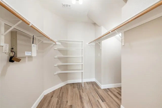a view of walk in closet with empty racks