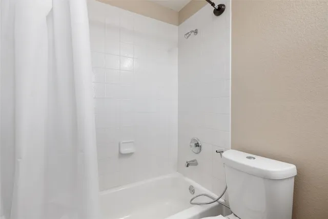 a bath room with a toilet and a bath tub