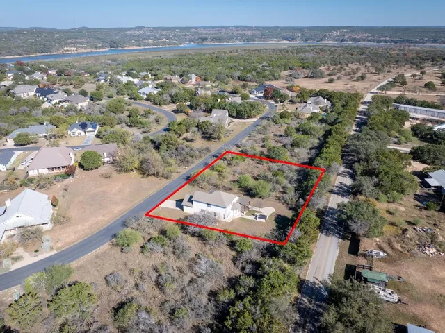 an aerial view of residential houses with outdoor space and trees