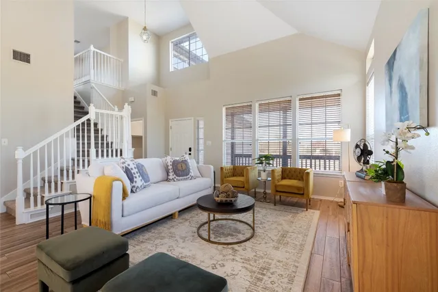 a living room with furniture wooden floor and a large window