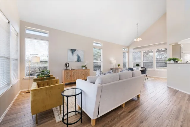 a living room with furniture wooden floor and large windows
