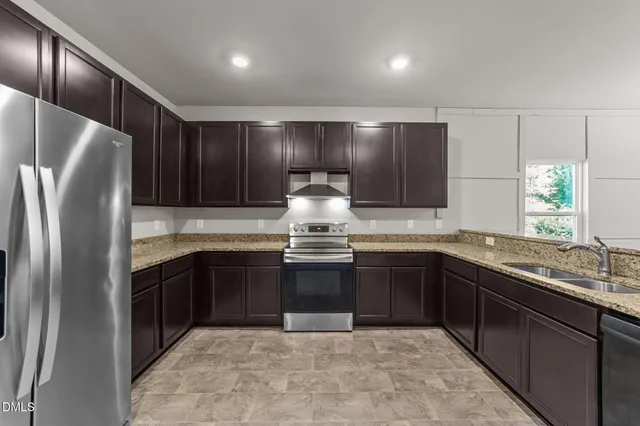 a kitchen with stainless steel appliances granite countertop a sink stove and refrigerator