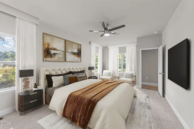 a bedroom with a bed a couch and a flat tv screen on the dresser