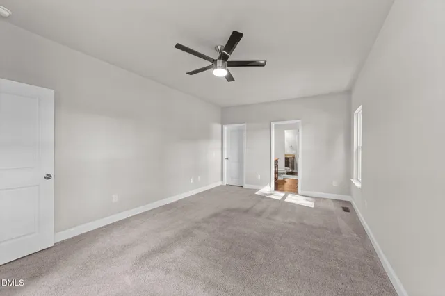 a view of empty room with ceiling fan