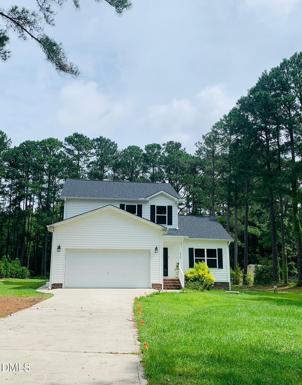 2504 Fleming Road Fuquay-Varina, NC 27526 - Photo 3 of 41 a front view of a house with a garden and trees