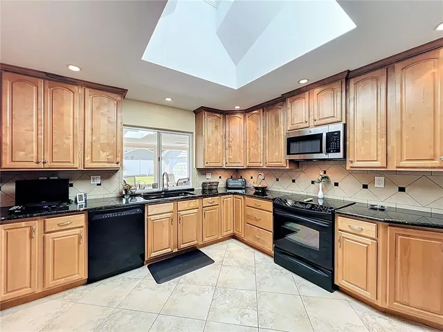 a kitchen with stainless steel appliances granite countertop a refrigerator and a stove top oven
