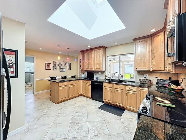 a kitchen with stainless steel appliances granite countertop a stove a sink and a refrigerator
