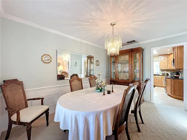 a view of a dining room with furniture and chandelier