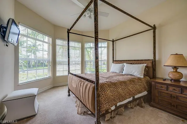 a bed sitting in a bedroom next to a window
