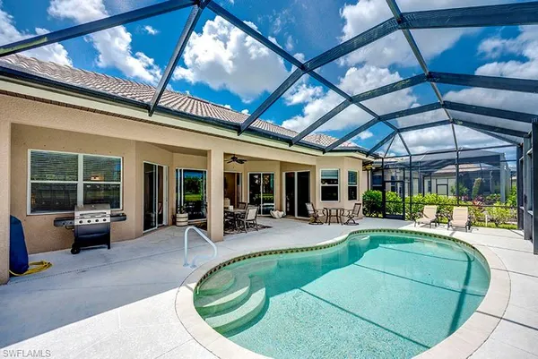 a view of a house with swimming pool and sitting area