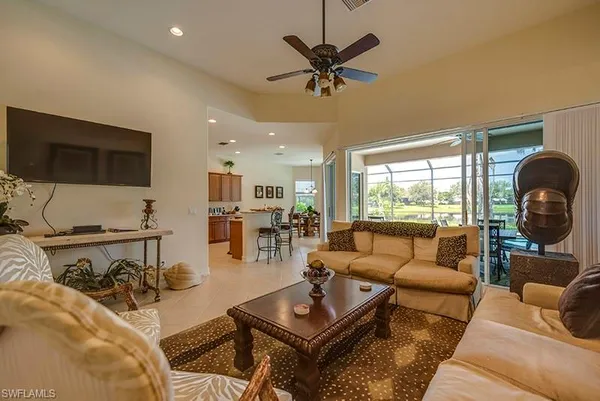 a living room with furniture a flat screen tv and a large window