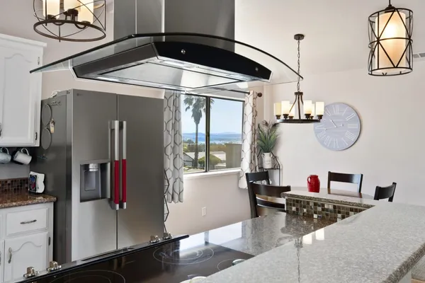 a kitchen with stainless steel appliances wooden floor dining table and chairs