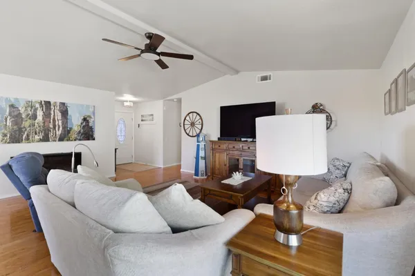 a living room with furniture and a wooden floor