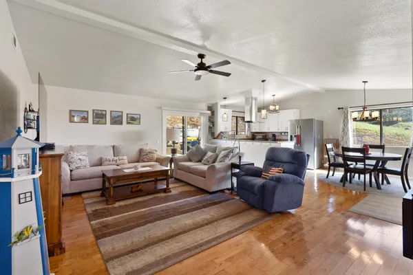 a living room with furniture kitchen view and a large window