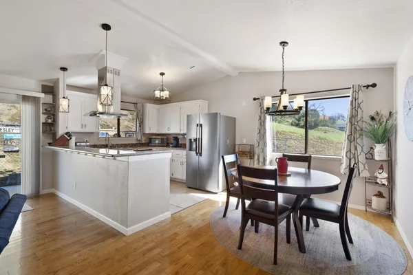 a dining room with furniture a chandelier and kitchen view