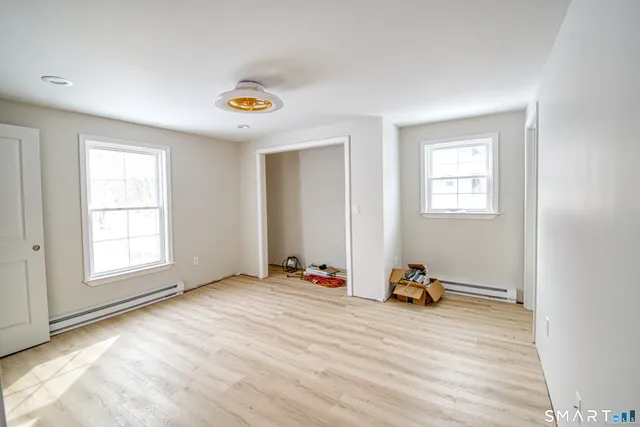 an empty room with windows and closet