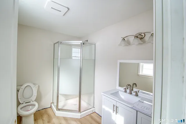 a bathroom with a granite countertop sink toilet and shower