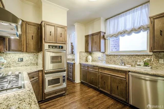 a kitchen with stainless steel appliances a stove a sink and a refrigerator