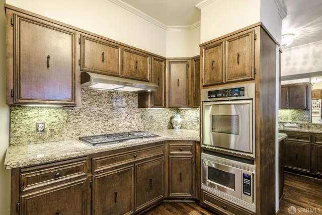 a kitchen with stainless steel appliances granite countertop a refrigerator and a stove