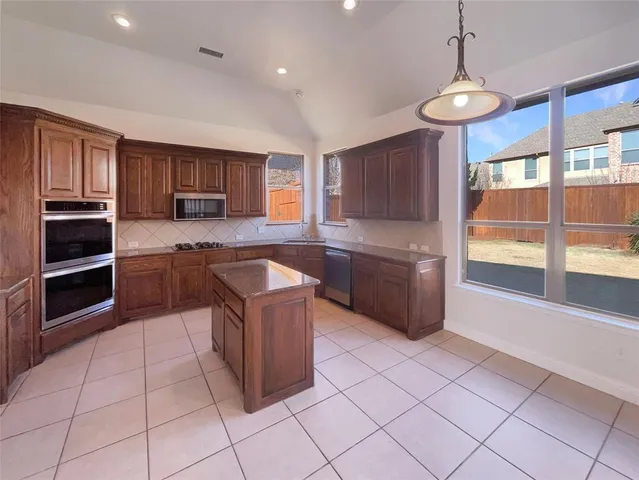 a kitchen with granite countertop a refrigerator and a sink