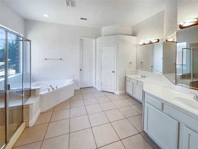 a large white bathroom with a granite countertop sink mirror and bathtub