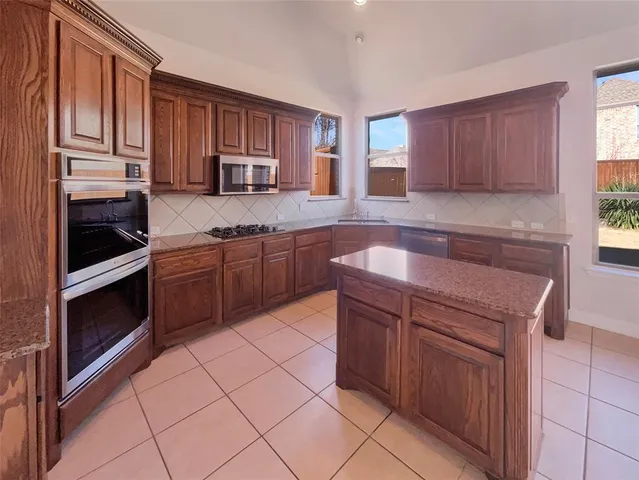 a kitchen with stainless steel appliances granite countertop a stove microwave and sink