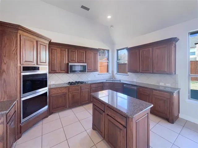 a kitchen with stainless steel appliances granite countertop a stove microwave and cabinets