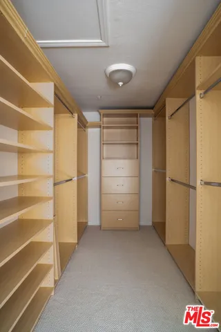 a view of walk in closet with empty racks