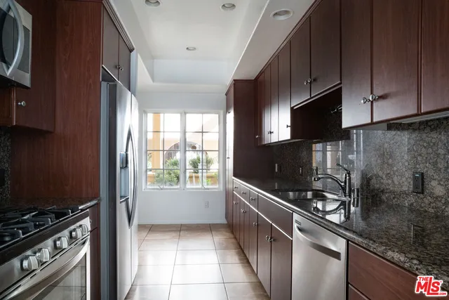 a kitchen with stainless steel appliances a sink a stove and cabinets