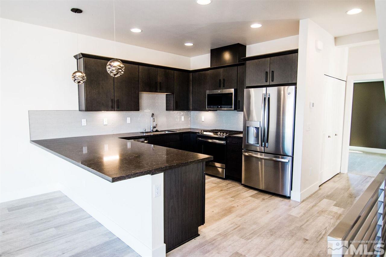 a kitchen with stainless steel appliances granite countertop a refrigerator and a sink