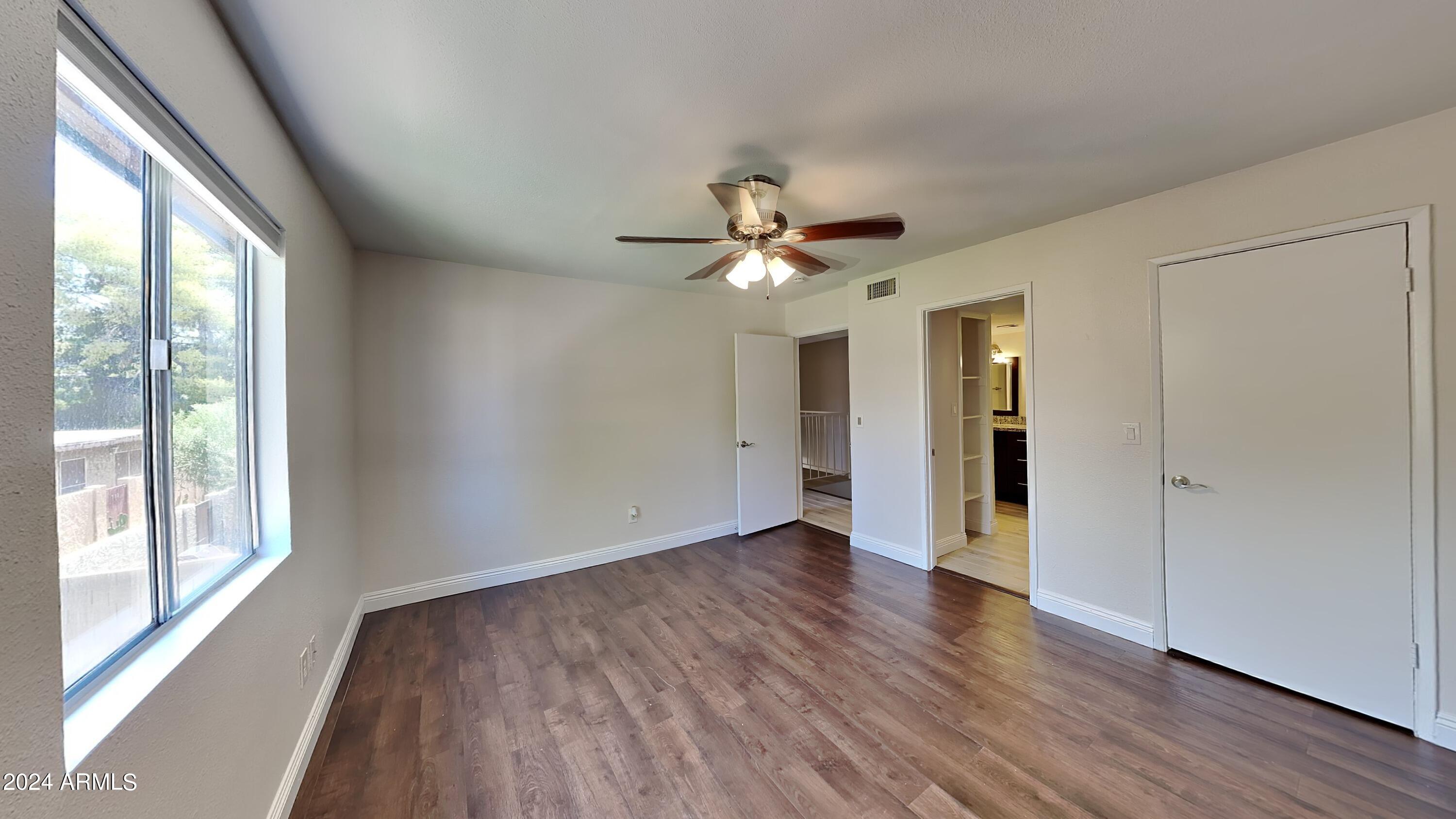 1051 South Dobson Road, Unit 166 Mesa, AZ 85202 - Photo 11 of 13 a view of an empty room with wooden floor and a window