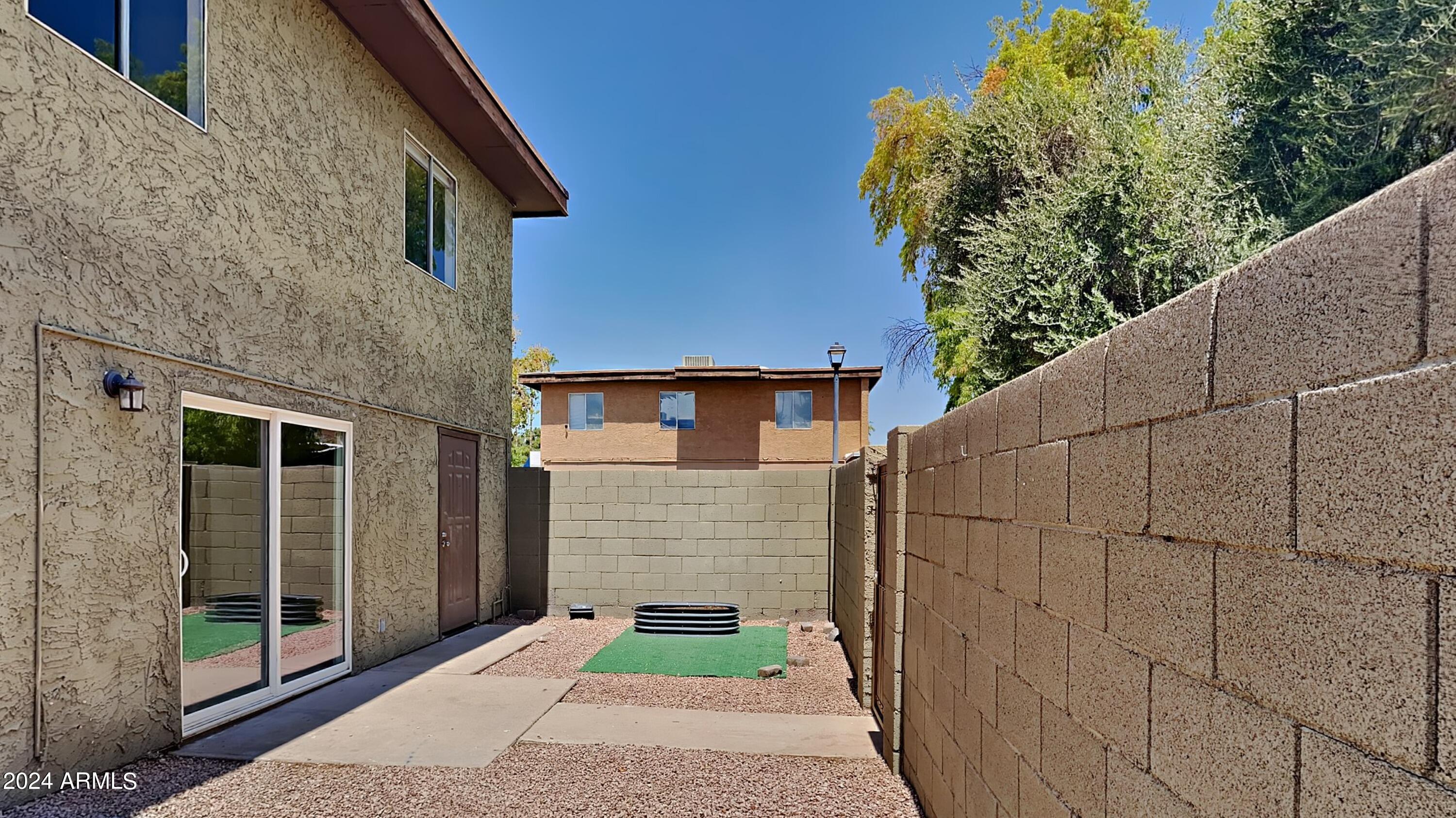 1051 South Dobson Road, Unit 166 Mesa, AZ 85202 - Photo 3 of 13 a brick house with a small yard and large window