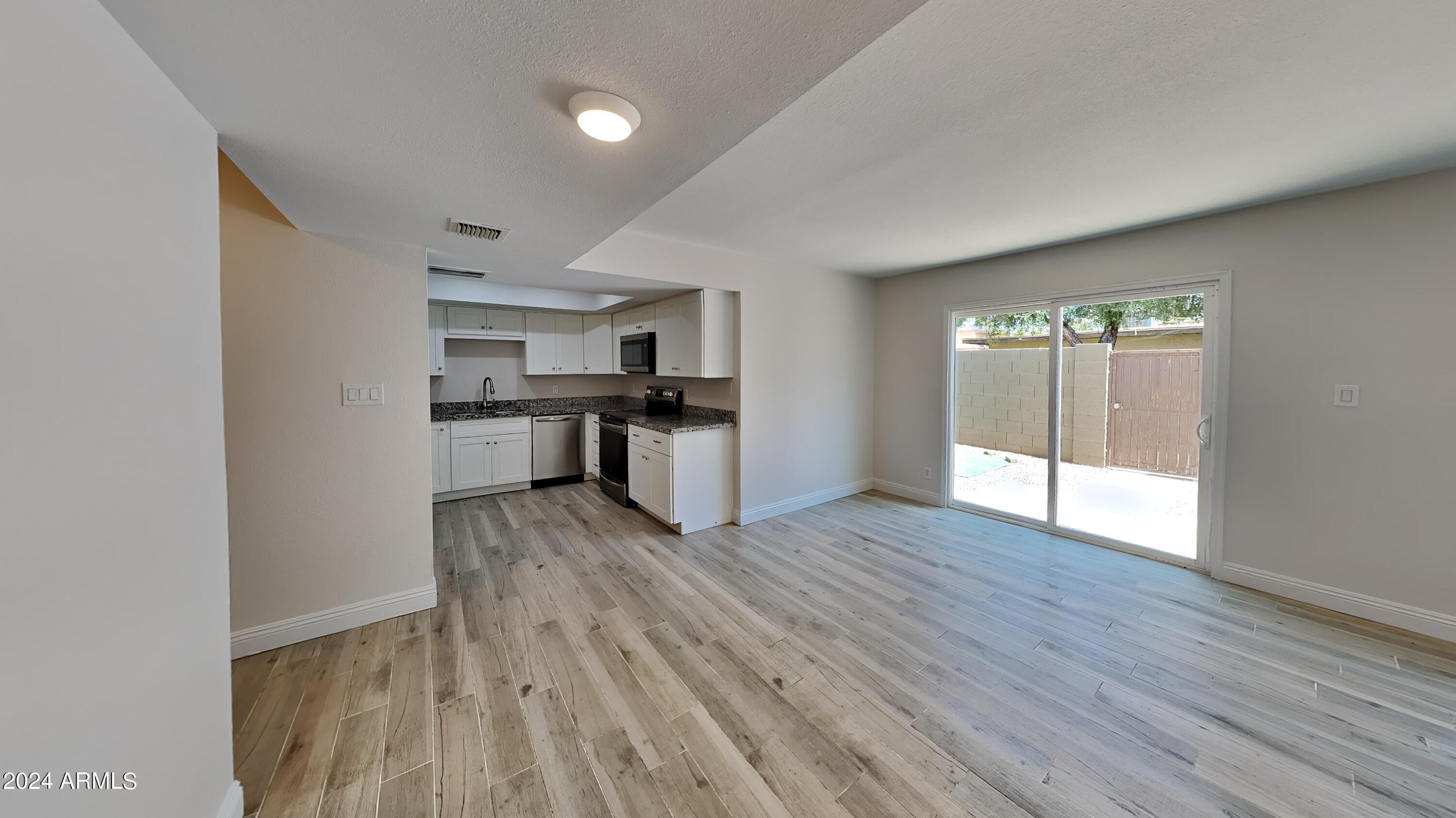 1051 South Dobson Road, Unit 166 Mesa, AZ 85202 - Photo 6 of 13 a view of a kitchen with a stove cabinets and wooden floor