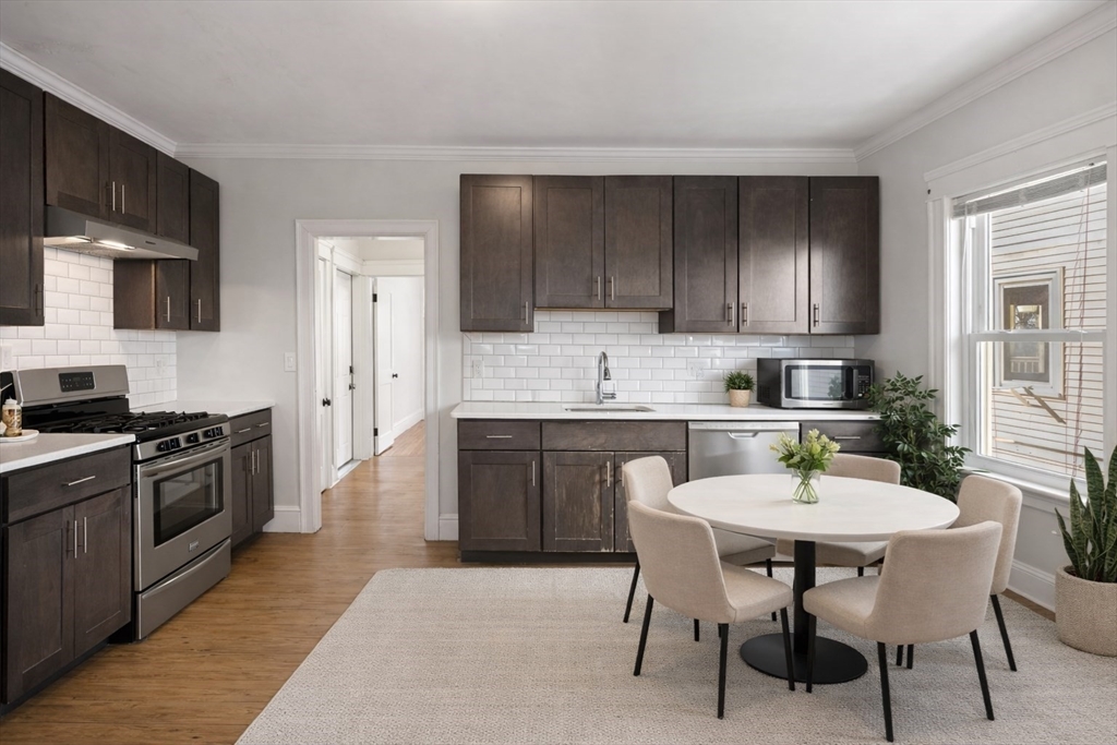 a kitchen with granite countertop a sink cabinets and stainless steel appliances