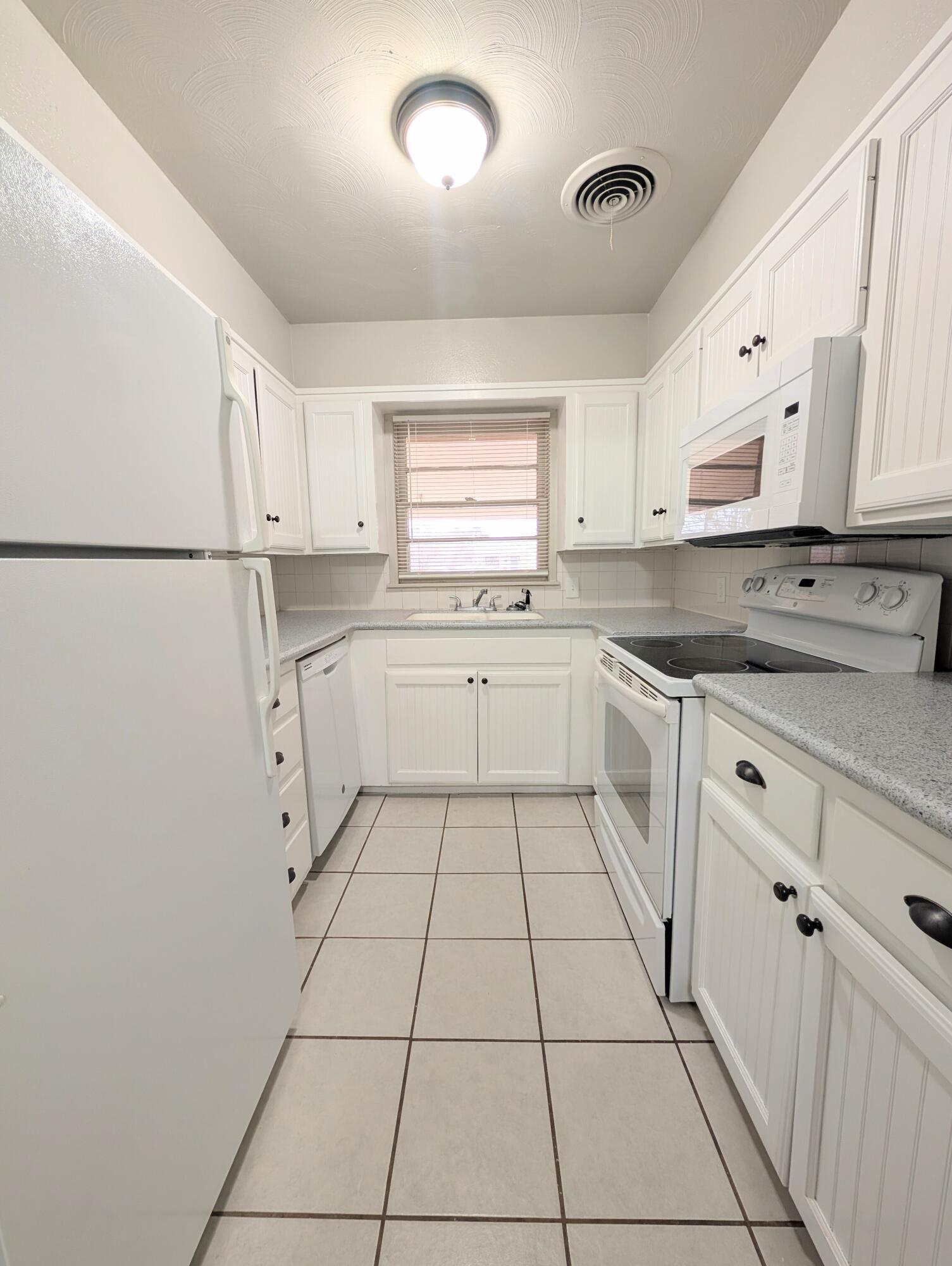 3221 33rd Street, Unit B Lubbock, TX 79410 - Photo 2 of 2 a kitchen with white cabinets appliances and a sink