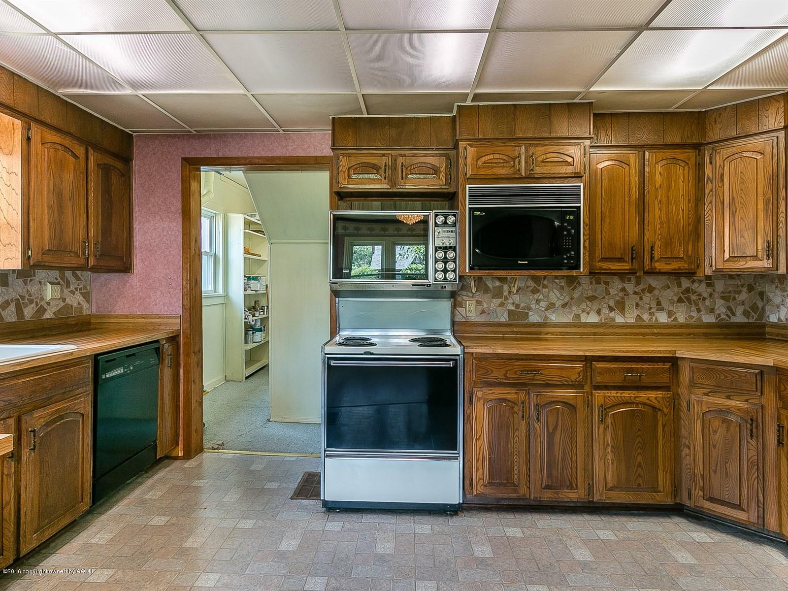 1227 South Bonham Street Amarillo, TX 79102 - Photo 8 of 25 a kitchen with stainless steel appliances granite countertop a stove and a microwave