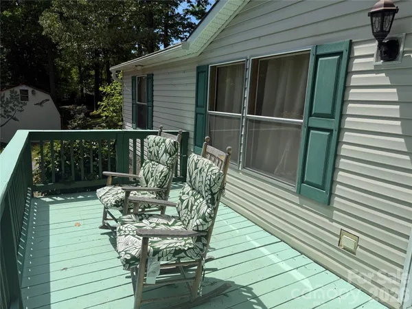 a balcony with wooden floor table and chairs