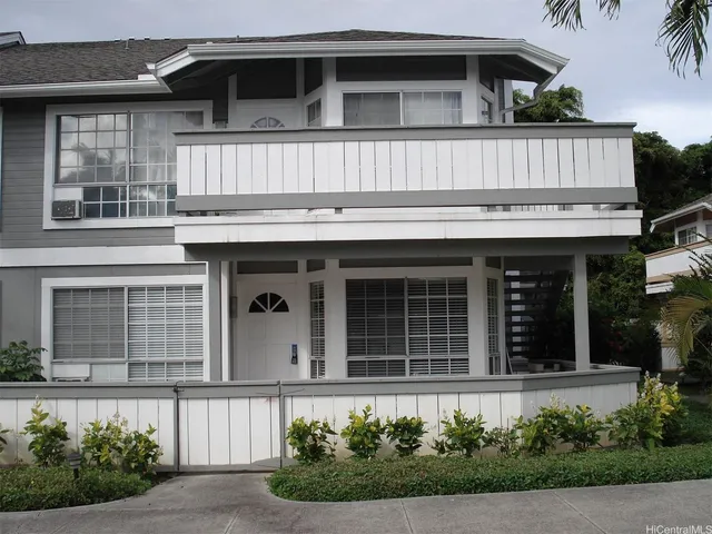 a front view of a house with plants