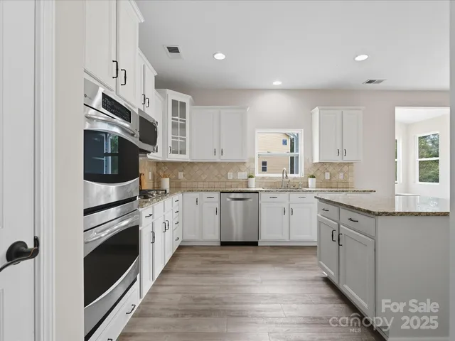 a kitchen with granite countertop cabinets stainless steel appliances and a counter space