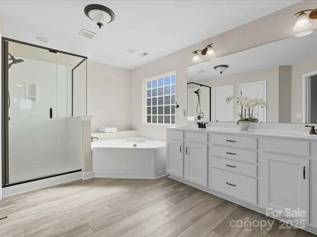a bathroom with a granite countertop sink mirror and a bathtub