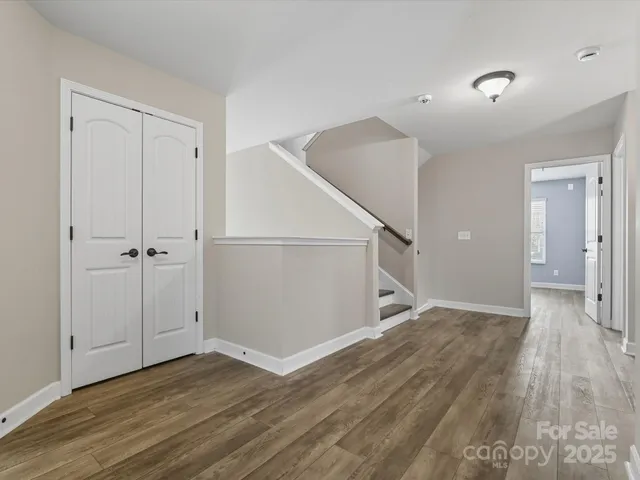 an empty room with wooden floor and entryway